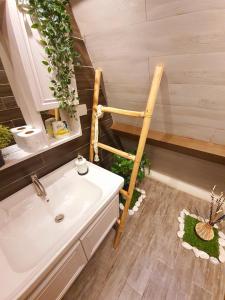 La salle de bains est pourvue d'un lavabo et d'une chaise en bois. dans l'établissement The Cabin by Grey - Vacation House and Events Place, à Kawit
