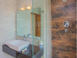 ein Badezimmer mit Waschbecken und Glasdusche in der Unterkunft Hotel Bodhiz TUSAL in Kathmandu