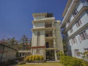 a tall white building with a balcony at Hotel Bodhiz TUSAL in Kathmandu