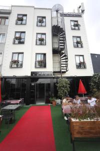 a large white building with a red carpet and a building at Yuvam akmarmara hotel in Istanbul