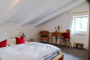 Schlafzimmer mit einem Bett, einem Schreibtisch und einem Fenster in der Unterkunft Alte Mühle mit wunderbarem Bergblick in Ramsau bei Berchtesgaden