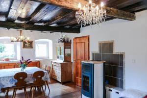 comedor con mesa y cocina con lámpara de araña en Alte Mühle mit wunderbarem Bergblick, en Ramsau