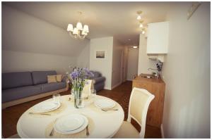 ein Wohnzimmer mit einem Tisch und einem Sofa in der Unterkunft Smėlynas Neringa Apartments in Neringa