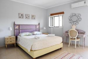a bedroom with a large bed and a desk at Villa Maxim in Corfu Town in Corfu