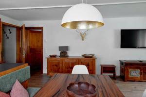 a dining room with a wooden table and a chandelier at Alpenhaus Montafon in Gargellen