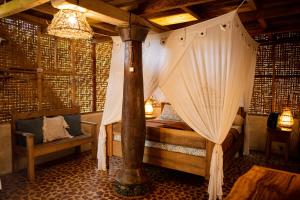 a bedroom with a canopy bed in a room at Rinjani Lighthouse in Senaru