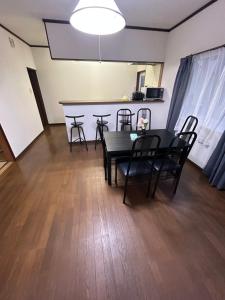 uma sala de jantar com uma mesa preta e cadeiras em 高島市一棟貸切 貸別荘グループファミリーok 大人数でご利用だとお得連泊がお得 em Takashima