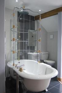魯辛的住宿－羽毛旅館，带白色浴缸的浴室和卫生间