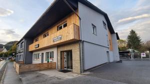 ein großes Gebäude mit Holzfassade in der Unterkunft Apartment- Zimmer Pernter in Köflach