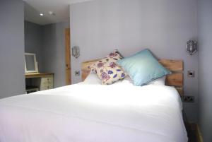 a white bed with two pillows on top of it at The Feathers in Ruthin