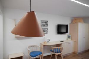 een kamer met een tafel en twee stoelen en een lamp bij Alpenhaus Montafon in Gargellen