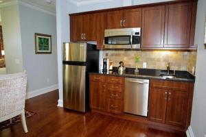 a kitchen with wooden cabinets and a stainless steel refrigerator at Norwalk Inn & Conference Center in Norwalk