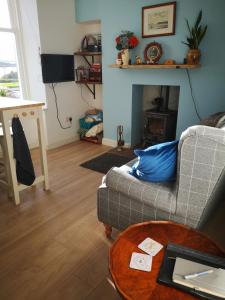 a living room with a couch and a table at Beside the Bay in Millport