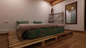 a bed on a wooden platform in a room at Kanatal Kutir in Kanatal