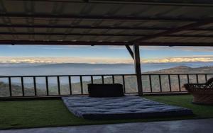 a room with a bed on a balcony with a view at Kanatal Kutir in Kanatal