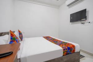 a bedroom with a bed and a desk and a tv at FabHotel Rooms 27 in Hyderabad