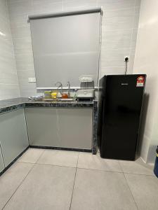 eine Küche mit einem schwarzen Kühlschrank im Zimmer in der Unterkunft SZ Home Legacy at Meritus in Perai
