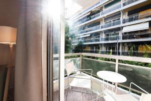 a balcony with a table and chairs and a building at Mandarin apartments by halu! in Thessaloniki