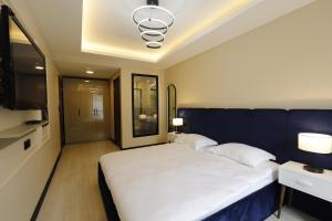 a bedroom with a large white bed with a blue wall at Ravello Suites Taksim in Istanbul +40 photos