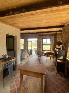 a living room with a table and a stove at Yellowwoods Farm - WILLOUGHBYS COTTAGE and OLD STABLES COTTAGE in Curryʼs Post
