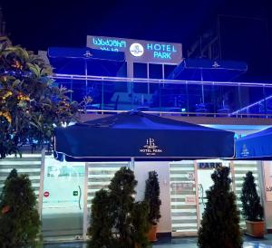 un paraguas azul frente a un aparcamiento del hotel en Hotel Park en Batumi