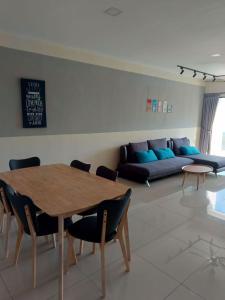 uma sala de estar com uma mesa e um sofá em Ipoh Manhattan Water Park Pool View Cozy Homestay em Ipoh