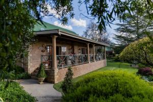 Andes Clarens Guesthouse في كلارينس: منزل من الطوب كبير مع سقف أخضر