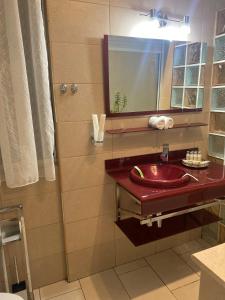 uma casa de banho com um lavatório vermelho e um espelho. em Central Luxury Apartament Nr 5 ***** em Bucareste