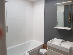 ein weißes Badezimmer mit einer Badewanne und einem Waschbecken in der Unterkunft Horizon View in South Hayling
