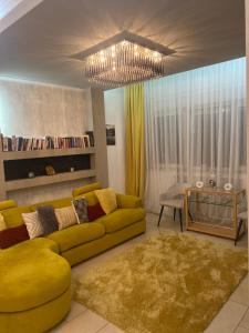 uma sala de estar com um sofá amarelo e uma mesa em Central Luxury Apartament Nr 5 ***** em Bucareste