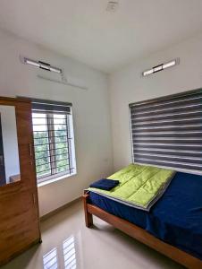 a bedroom with a bed and a window at starhive in Kalpetta