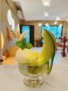un bol de fruta con una hoja verde sobre una mesa en 如沐咖啡旅宿, en Xingjian
