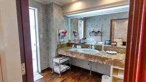 łazienka z umywalką i dużym lustrem w obiekcie ホテルシエル沼津店 -大人専用- w mieście Saint Neots