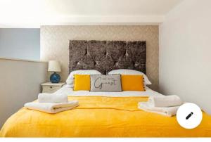 a bedroom with a large yellow bed with towels on it at Fabulous City Centre Apartments - Special Occassion Packages Available in Liverpool