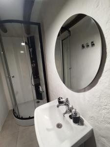 een badkamer met een witte wastafel en een spiegel bij La Afortunaa in Valdelarco