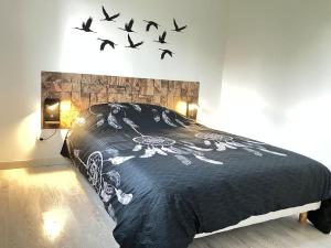 a bedroom with a bed with birds flying above it at Séjour bucolique au lac du der in Giffaumont-Champaubert