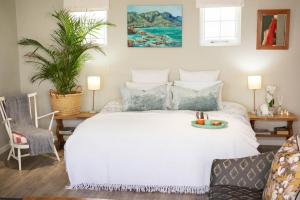 Un dormitorio con una cama blanca con un plato de fruta. en Goozi Garden Cottage, en Hermanus