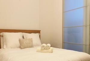 um quarto com uma cama com duas toalhas em London SW Holiday Apartment - Free parking em Londres