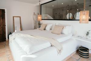 a white bed in a room with a mirror at Hearts & Home in Mijas