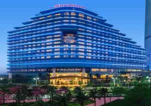 a large blue building with lights in front of it at Sheraton Zhuhai Hotel in Zhuhai
