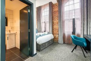 a bedroom with a bed and a bathroom with windows at Stylish 1-Bed Studio - Heart of Nottingham in Nottingham
