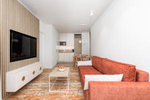 ein Wohnzimmer mit einem Sofa und einem TV in der Unterkunft Rent like home - Bel Mare F302 in Misdroy