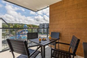 a table and chairs on a balcony with a view at Rent like home - Bel Mare F302 in Międzyzdroje