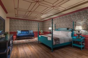 um quarto com uma cama azul e uma cadeira azul em Hillcreek Gardens Tagaytay em Alfonso
