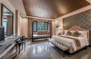 a bedroom with a bed and a desk and a television at Hillcreek Gardens Tagaytay in Alfonso