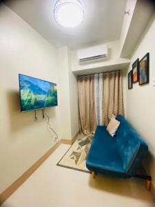 a living room with a blue couch and a flat screen tv at SHORE RESIDENCES 1 BD UNIT FOR RENT in Manila