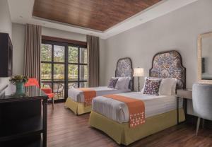 a hotel room with two beds and a balcony at Hillcreek Gardens Tagaytay in Alfonso