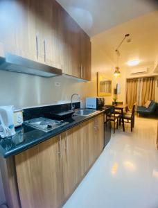 a kitchen with wooden cabinets and a dining room at SHORE RESIDENCES 1 BD UNIT FOR RENT in Manila