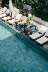 a swimming pool with chaise lounges and lounge chairs at Primus Otel in Ildır