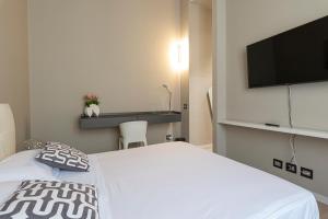 una camera con letto bianco e TV a schermo piatto di Deluxe apartment Milia Agrigento a Agrigento